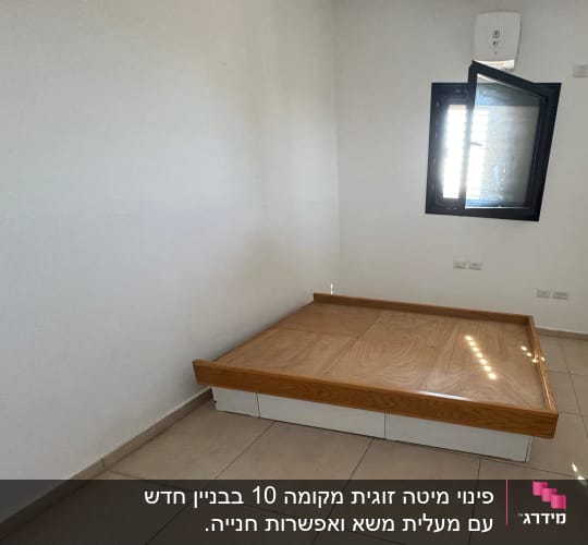 חדר ריק עם מיטה נמוכה ליד חלון פתוח